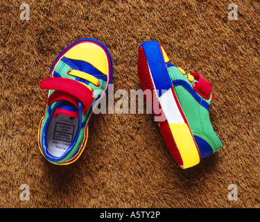 Paar von hellen Multi farbige Kinder Schuhe auf Borsten Fußmatte. Stockfoto