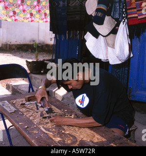 Lokale Mann arbeitet an Holzschnitzereien neben seinem Geschäft, Luang Prabang, Laos. Stockfoto