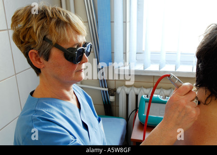 Polen, Lodz, weiblichen Therapeuten Behandlung von Patienten mit Laser, Seitenansicht Stockfoto