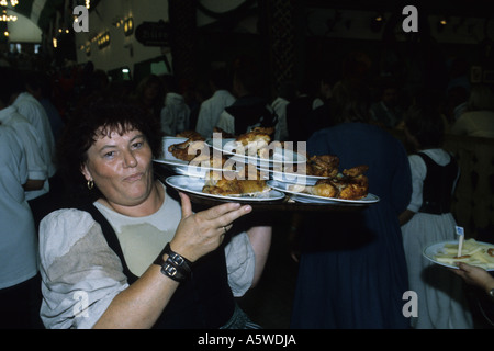 Wiesn-Kellnerin mit Brathähnchen Stockfoto