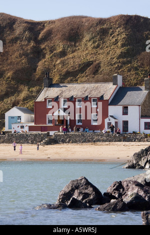 Blick über Meer, rote Ty Coch Inn Pub an einem Strand in Porth Dinllaen Village in der Bucht auf Lleyn Halbinsel North Wales UK Großbritannien Stockfoto