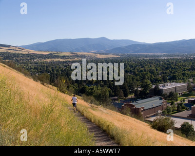 Mann, jogging am Bergweg auf Mount Sentinel. Missoula, Montana. Campus der Universität von Montana auf der rechten Seite. Stockfoto