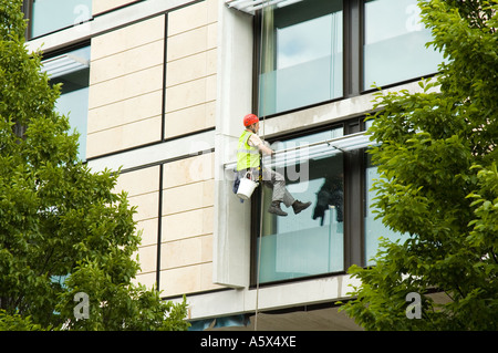 Fenster-Reiniger mit industriellen Seiltechnik Zugang bei der Arbeit auf einem Hotelgebäude, Manchester, UK Stockfoto