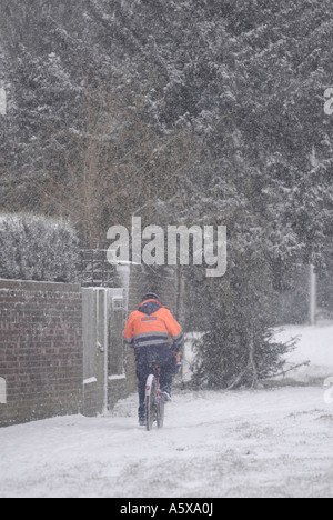 Postbote arbeitet hart an einem schneereichen Wintern Morgen England Stockfoto