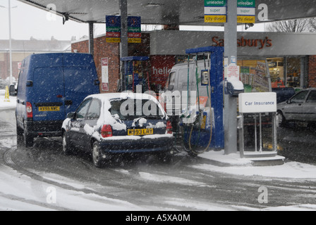 Fahrzeuge tanken von Kraftstoff an einer Tankstelle Sainsburys an einem winterlichen Morgen in England. Stockfoto
