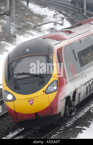 Jungfrau-Züge Pendolino Class 390 trainieren auf der West Coast Main Line in Richtung Süden in den Schnee und das Eis England Stockfoto