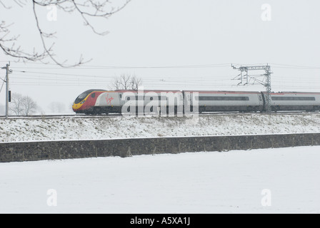 Jungfrau-Züge Pendolino Class 390 trainieren auf der West Coast Main Line in Richtung Süden in den Schnee und das Eis England Stockfoto