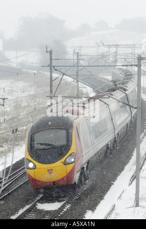 Jungfrau-Züge Pendolino Class 390 trainieren auf der West Coast Main Line in Richtung Süden in den Schnee und das Eis England Stockfoto