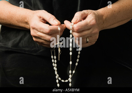 Die Hand einer Frau Rosenkranz beten halten Stockfoto