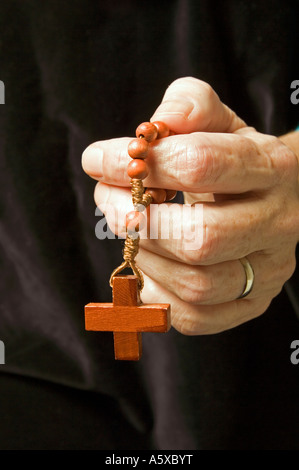 Die Hand einer Frau halten Jahrzehnts Rosenkranz beten Stockfoto