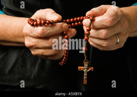 Die Hand einer Frau Rosenkranz beten halten Stockfoto