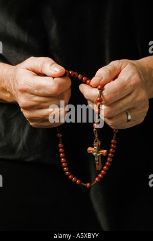 Die Hand einer Frau Rosenkranz beten halten Stockfoto