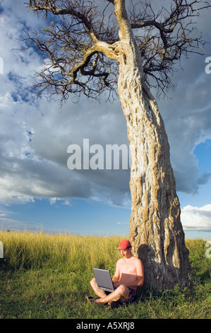 Junger Mann mit einem Laptop-Computer in der Masai Mara Nationalpark Kenia Stockfoto