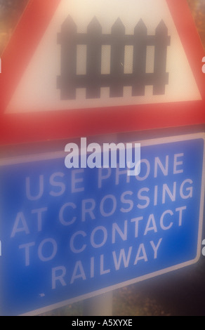 Atmosphärische Roadsign bezeichnet Bahn Bahnübergang Tor mit Worten Nutzung Telefon an der Kreuzung Eisenbahn kontaktieren Stockfoto