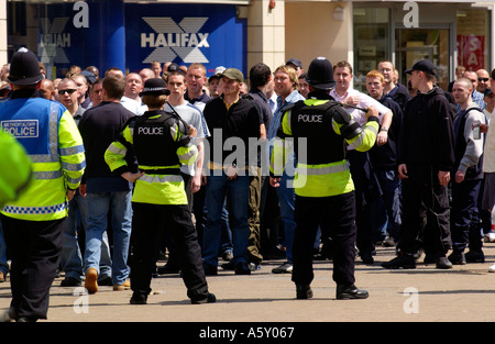 Polizisten Schlagstöcke Uhr über eine Gruppe von Fußballfans im Zentrum von Cardiff in der Stadt für das FA-Cup-Finale gezogen Stockfoto