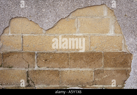 Nahaufnahme eines Teils der Blockwand geknackt Brise ausgesetzt wegen ein großes Loch in der Zement-rendering Stockfoto