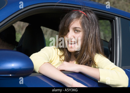 Junge Teenager Mädchen lehnt sich aus dem Fenster eine blaue Porsche Sportwagen UK Stockfoto