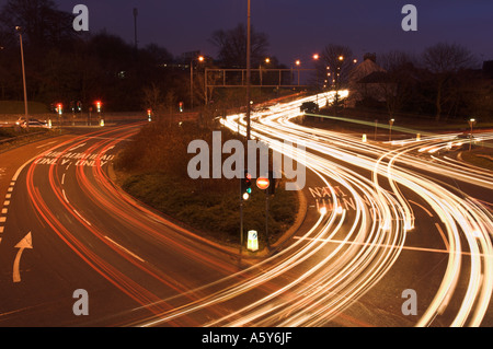 Lichtspuren des Verkehrs an einer viel befahrenen Straßenkreuzung mit Ampeln England UK Stockfoto