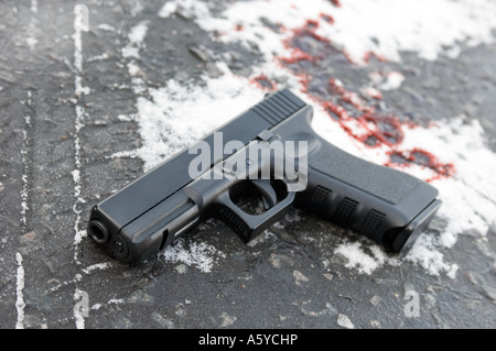 eine Glock automatische Pistole liegen im Schnee mit Blutflecken (Replikat Pistole) Stockfoto