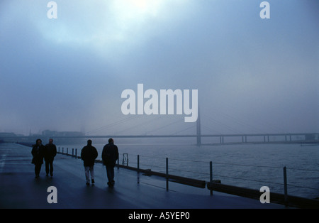 Passanten am Flussufer im Nebel, Rhein River, Düsseldorf, Nordrhein-Westfalen, Deutschland Stockfoto