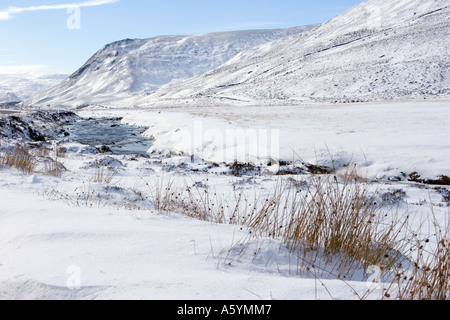 Glen Clunie Water auf der Straße nach Glenshee, schneebedeckte Ufer und gefrorener Fluss, Braemar nahe der A93 Road nach Glenshee, Schottland Großbritannien Stockfoto