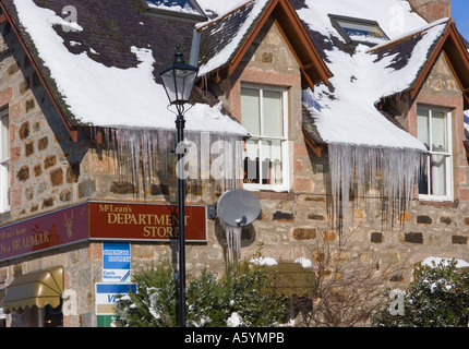 Gebäude in lange Eiszapfen hängen vom Dach der McLeans Souvenirshop im Winter überdacht, Braemar Royal Deeside Cairngorms National Park, Schottland Großbritannien Stockfoto