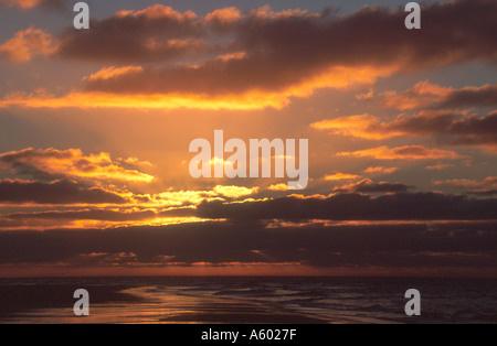 UNTERGEHENDE SONNE ÜBER GEZEITEN STRAND HUNSTANTON NORFOLK EAST ANGLIA ENGLAND UK Stockfoto