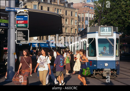 Touristen, die neben einer Straßenbahn in die Stadt, Bellevue-Platz, Zürich, Schweiz Stockfoto