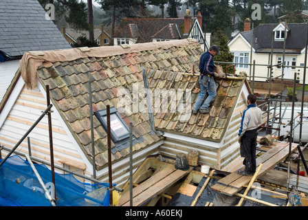 DACHDECKER BEI DER ARBEIT MACHT EIN NEUES DACH MIT ALTEN PANTILES SAFFRON WALDEN ESSEX ENGLAND Stockfoto