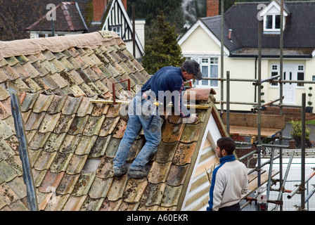 DACHDECKER BEI DER ARBEIT MACHT EIN NEUES DACH MIT ALTEN PANTILES SAFFRON WALDEN ESSEX ENGLAND Stockfoto