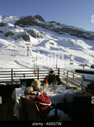 Junges Paar sitzt auf der Terrasse des Restaurants in der Nähe von Ischgl in Österreich Alpenhaus Stockfoto