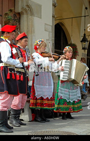 Vertikale Nahaufnahme von kostümierten Musikern den "Sukiennice" Tuchhallen auf dem Main-Marktplatz "Rynek Glowny" vor. Stockfoto