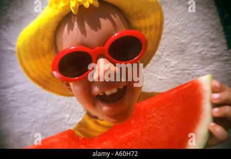 Spaß Urlaub gesund WASSERMELONE EIN FOTO MOMENT Mädchen in bunten Hut und Sonnenbrille essen Wassermelone in Urlaub Lage Stockfoto