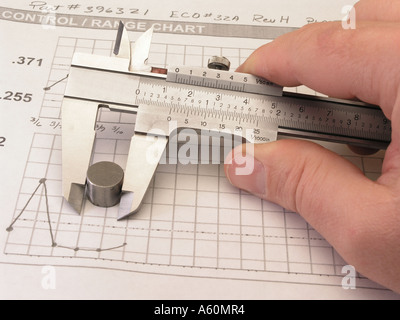 Bremssattel (metrische und Englische Maßeinheiten) messen Teil mit SPC-Diagramm im Hintergrund Stockfoto