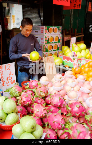 Hong Kong, China. Obst stall Anbieter in Lady Market in Mong Kok Bereich von Kowloon. Rosa Drachenfrucht, Äpfel, Orangen Stockfoto