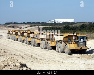 Caterpillar-Kipper sieben LKWs auf einer neuen Autobahnbaustelle, um eine Verbindungsstraße zum Flughafen Stansted in der Nähe von Takeley in Essex England, Großbritannien, zu bilden Stockfoto