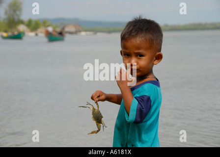 Süße junge spielt mit einer Krabbe in seiner Hand Ream National Park-Kambodscha Stockfoto