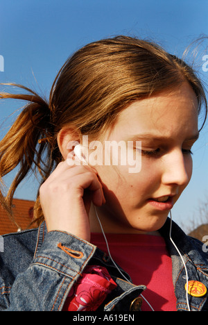 Mädchen hört Musik mit dem Apple IPod shuffle2 MP3 Player Stockfoto