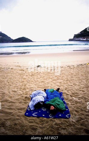 Flüchtlinge, die schlafen auf einem Strand, San Sebastian, Nordspanien Stockfoto