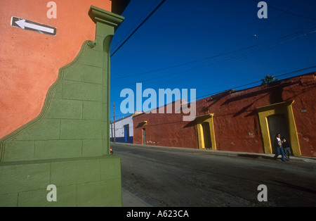 Mexiko Oaxaca Staat Oaxaca City Corner grün und Orange lackiert Gebäude mit weißer Pfeil auf schwarzem Hintergrund zeigt links Stockfoto