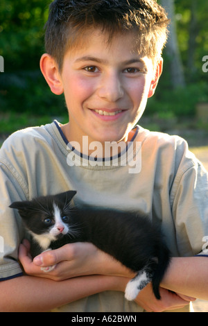 Porträt eines jungen Mannes, der eine Kätzchen im Arm halten Stockfoto
