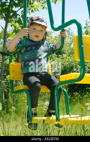 Portrait eines kleinen Jungen auf einer Schaukel Stockfoto