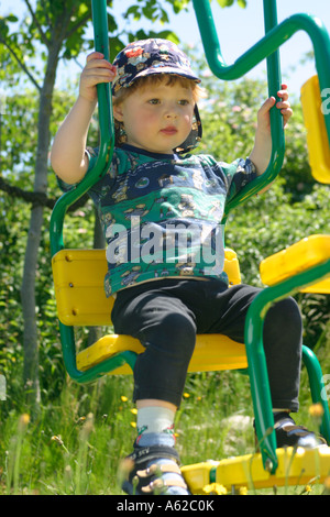 Portrait eines kleinen Jungen auf einer Schaukel Stockfoto