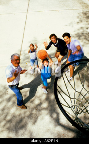 Drei Generationen der hispanische Familie mit Spaß, spielen Basketball zu Hause in Einfahrt von oben Stockfoto