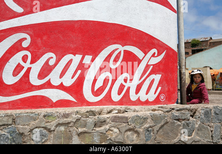 Junges Mädchen neben Coca-Cola Schild, Tiquina, Titicacasee, Bolivien, Südamerika Stockfoto