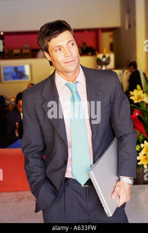 Unternehmer stehen und halten einen laptop Stockfoto