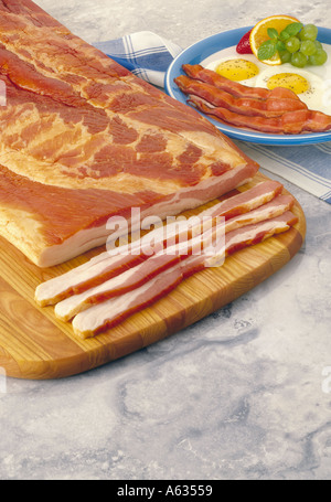 Speck Schweinefleisch ganze Platte und in Scheiben geschnitten und vorbereitete Speck und Eiern überzogen servieren auf grauem Marmor Hintergrund Stockfoto