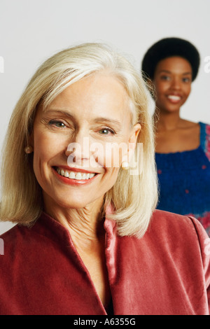 Portrait einer älteren Frau lächelnd mit einer jungen Frau im Hintergrund Stockfoto