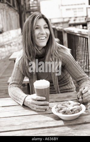 Reife Frau hält ein Glas Schoko Milchshake und lächelnd Stockfoto