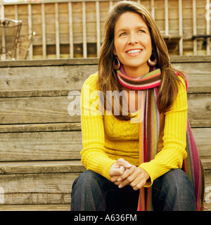 Eine junge Frau auf die Holzstufen lächelnd in Nahaufnahme Stockfoto